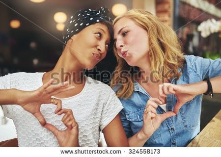 stock-photo-two-women-ethnic-friends-kissing-each-other-for-fun-324558173